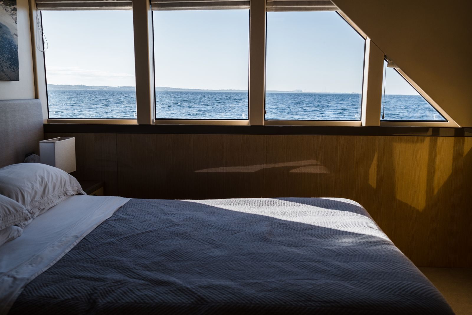 Bed facing wide windows over the sea, the kind of room a guarantee cabin might turn out to be