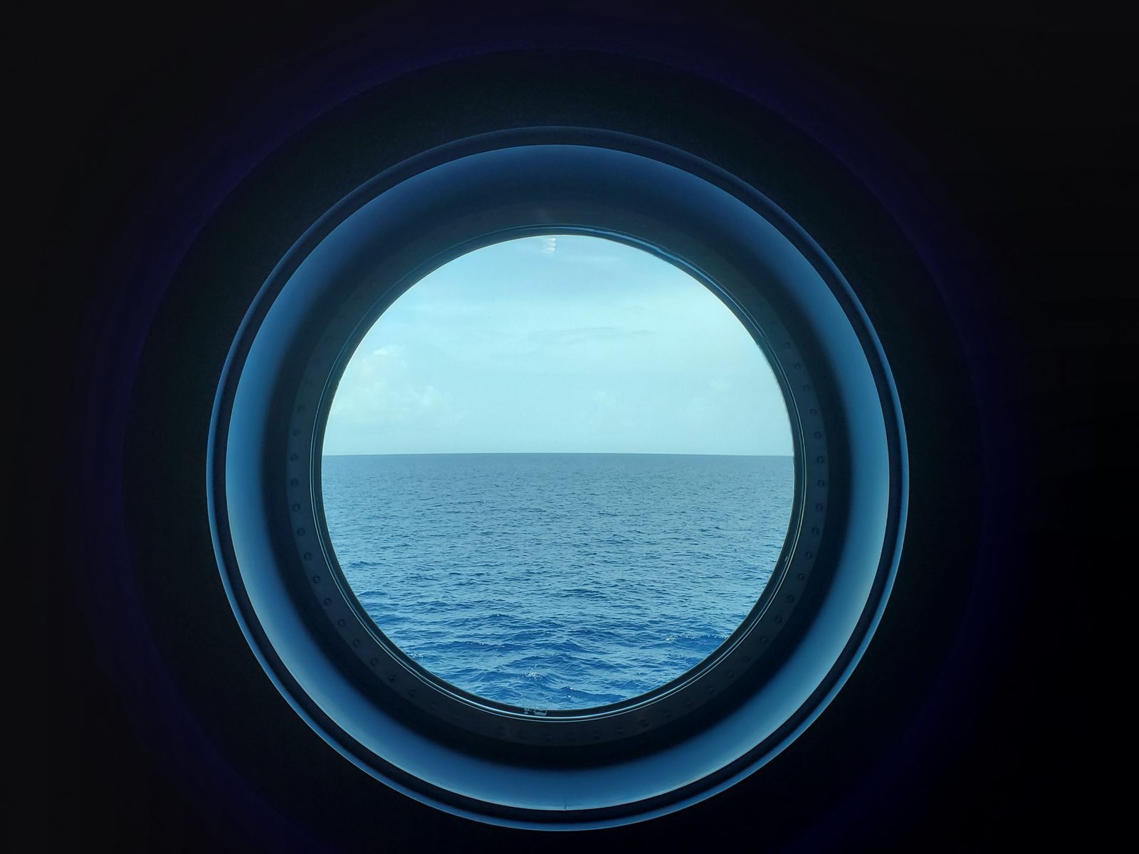 Open sea seen through a round ship porthole
