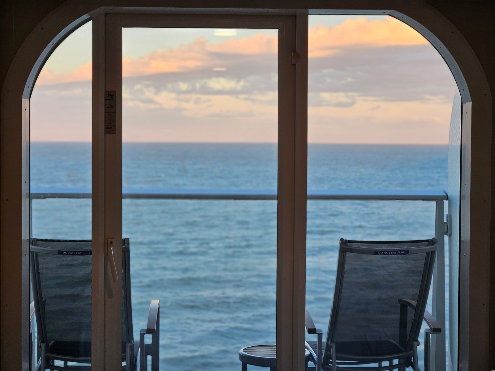 Balcony doors open to the ocean at sunset, the view standby cruises hope for